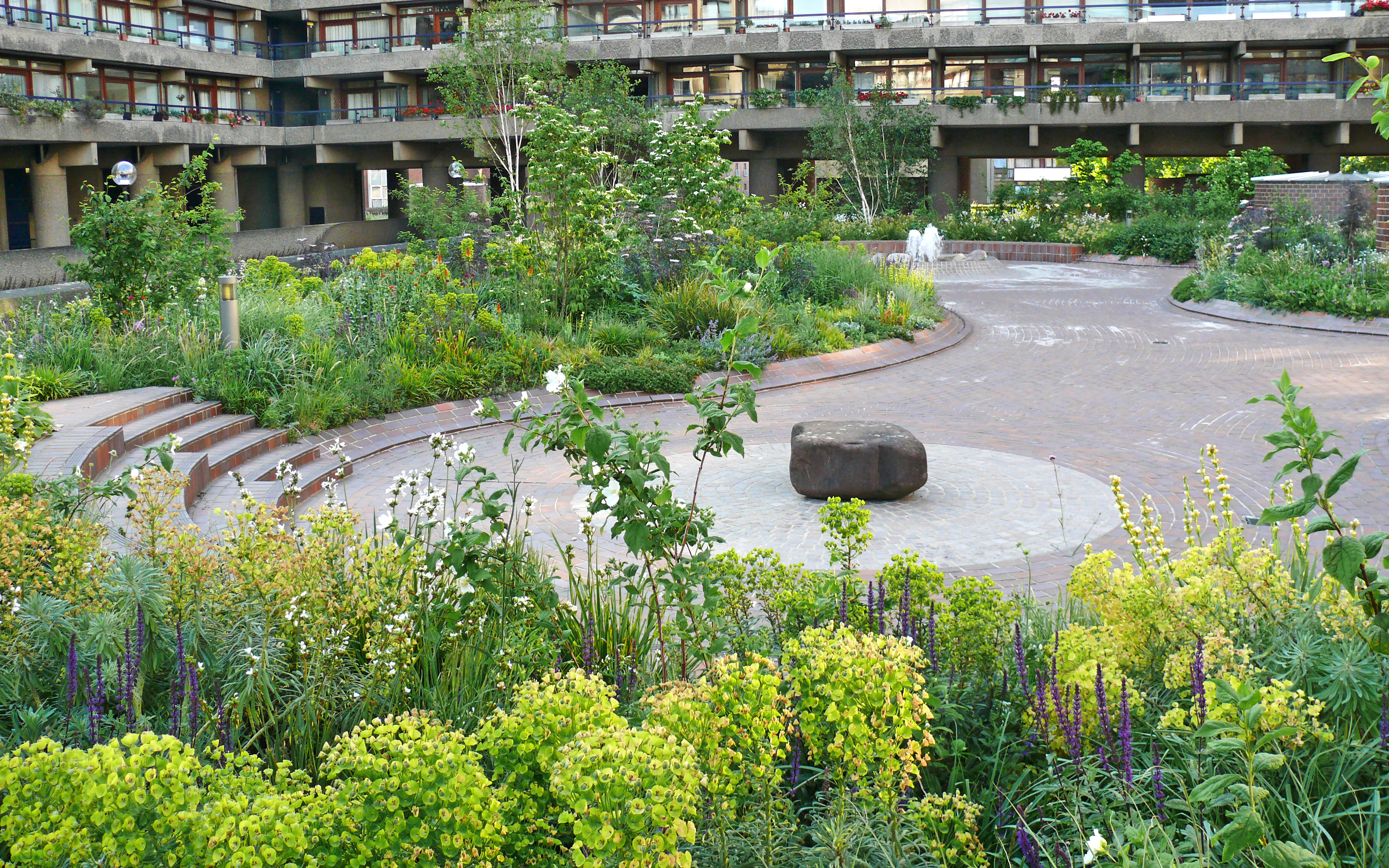 Various seating areas encourage visitors to rest and enjoy the views. Plant beds with flowers and water feature surrounded by residential bocks
